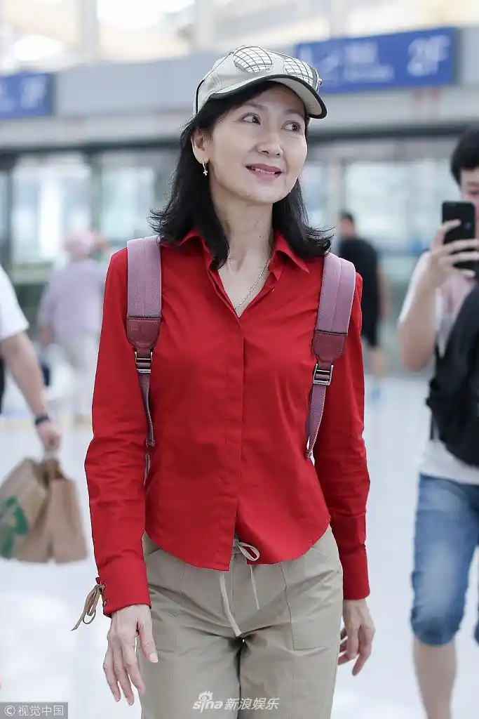 组图:60岁"小青"陈美琪红衣亮眼身段苗条 一路微笑不惧露鱼尾纹