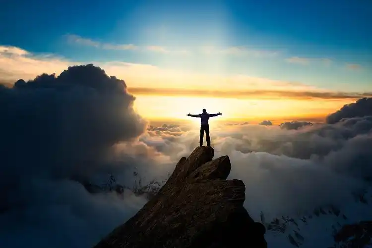 日落时分,一个人站在山顶上的剪影图片下载