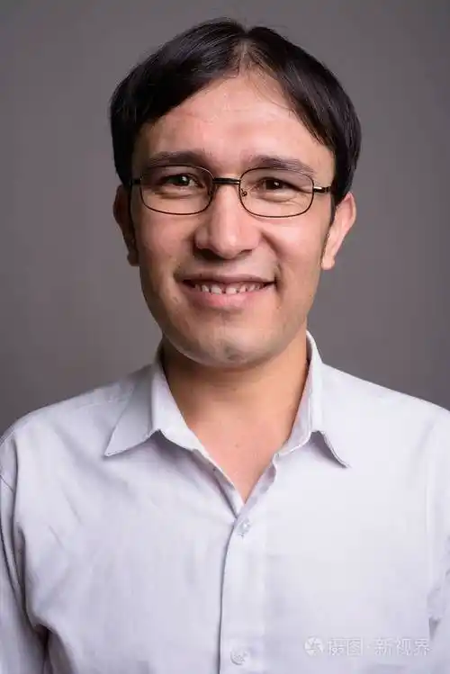 年轻的亚洲书在灰色背景下戴眼镜照片-正版商用图片08xxgp-摄图新视界