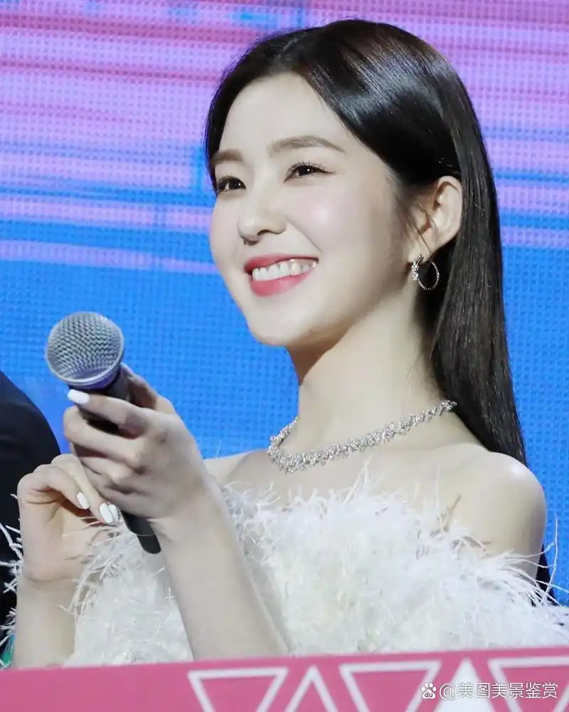 "韩国明星斐珠泫身穿白色羽毛裙,笑容满面,像一只展翅飞翔的白天鹅.