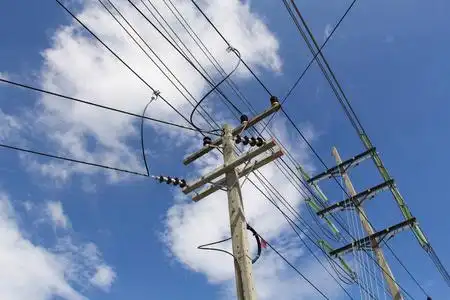 电线杆连接到蓝天背景上的高压电线上.照片