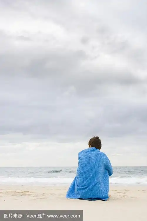 孤独的女人坐在海滩上