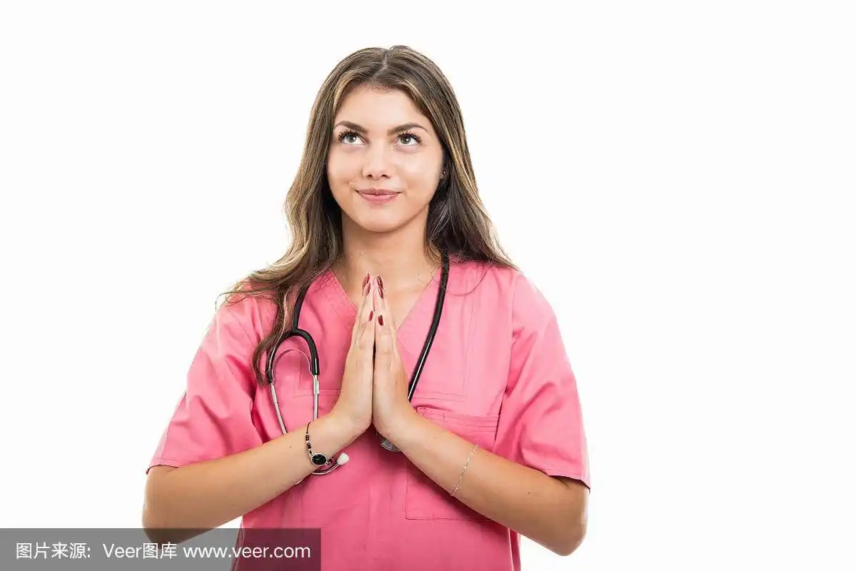 年轻漂亮的医生穿着手术服做祈祷手势的肖像