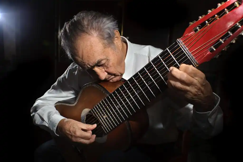 老音乐家.,一名老翁在玩吉他的白衬衫.黑暗的背景.