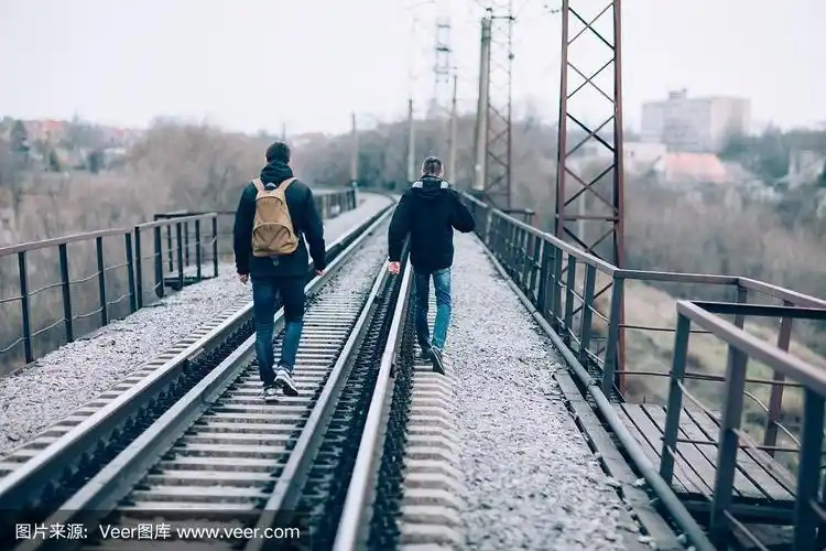 两个人在铁路上走开的背影