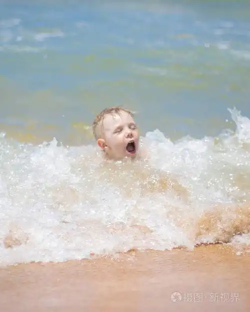 小男孩在海里游泳, 在纯净的波浪中奔跑和飞溅