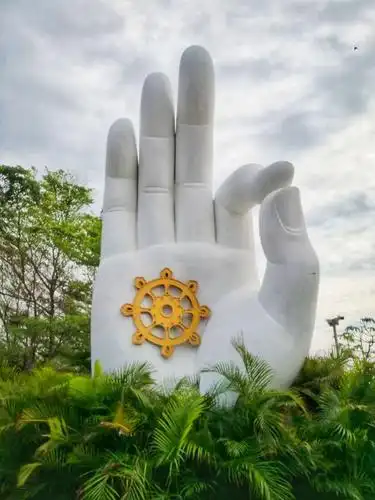 一体三尊造型的观音一面手持佛珠,一面手持莲花,一面手持经书(箧),各