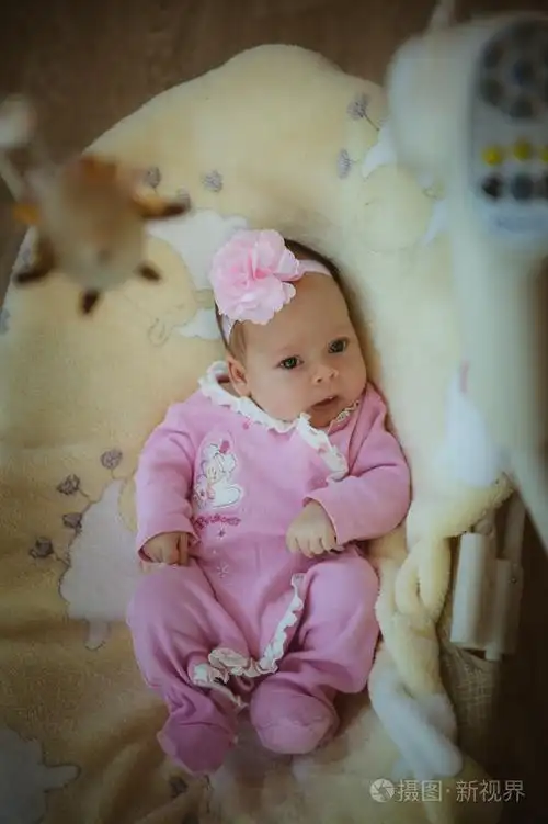 照片 可爱的小女孩,在室内套粉红色的西装的形象.刚出生的婴儿.jpg