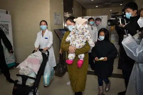 2月14日,奇奇(化名)在妈妈的怀抱中准备出院.新华社发(彭子洋 摄)