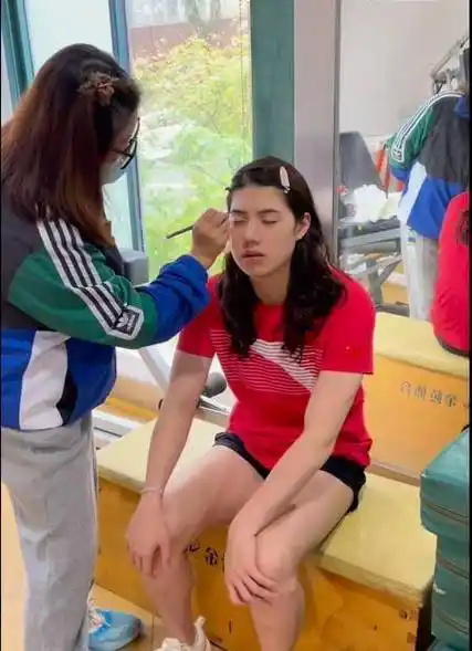 视频中,从不喜欢化妆的张雨霏坐在南京体育学院体育馆的一角,化妆师