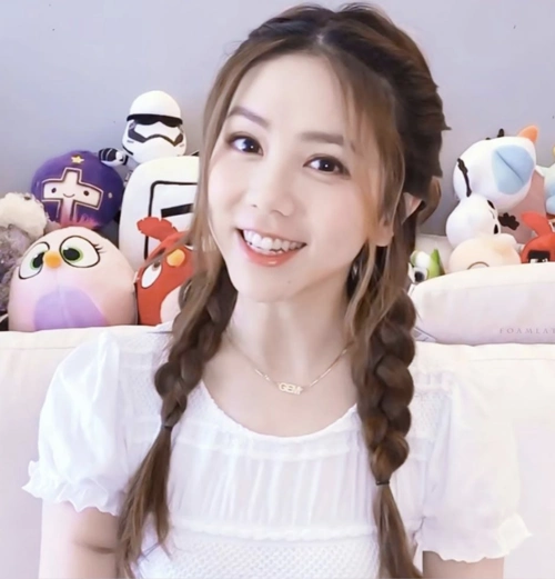 邓紫棋扎双麻花辫甜笑少女感足 身后娃娃堆成亮点抢镜