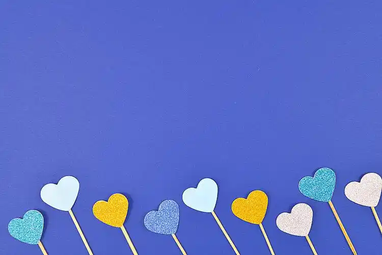 蓝色的情人节背景与闪闪发光的淡蓝色和白色的纸心在底部和上面的空白