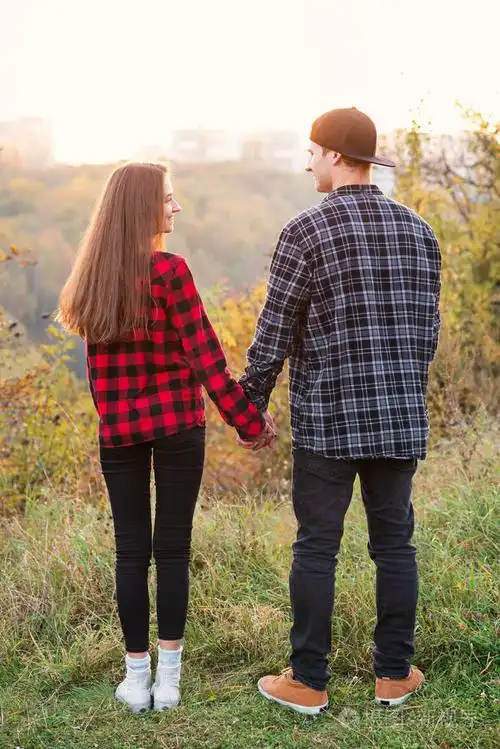 关闭年轻人和他的女朋友穿着休闲服牵手.