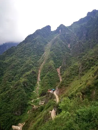 沿着矿区搭建的铁梯爬行到六号矿洞,在矿洞旁有一陡峭的山路直插山顶