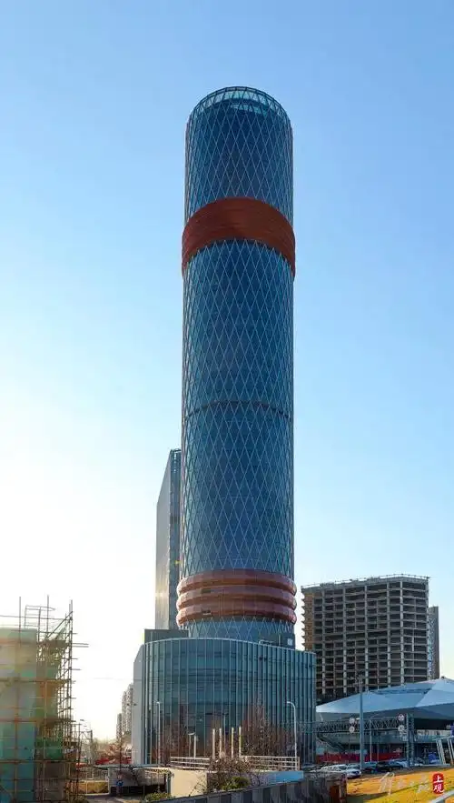 圆柱形的"通天宝塔",深蓝色的幕墙玻璃外装,"腰际"和"颈部"紫金色的"