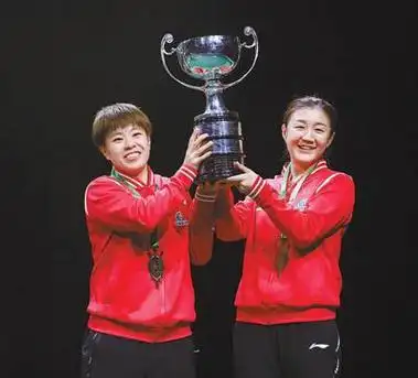 当地时间5月27日,女双冠军陈梦/王艺迪(左)在颁奖仪式上捧起奖杯.