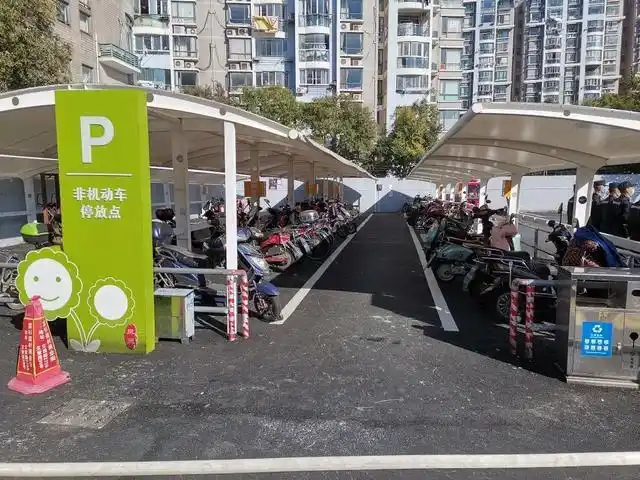 改造后的非机动车智能停车棚"以前我们都是停到店铺门口,用接线板充电
