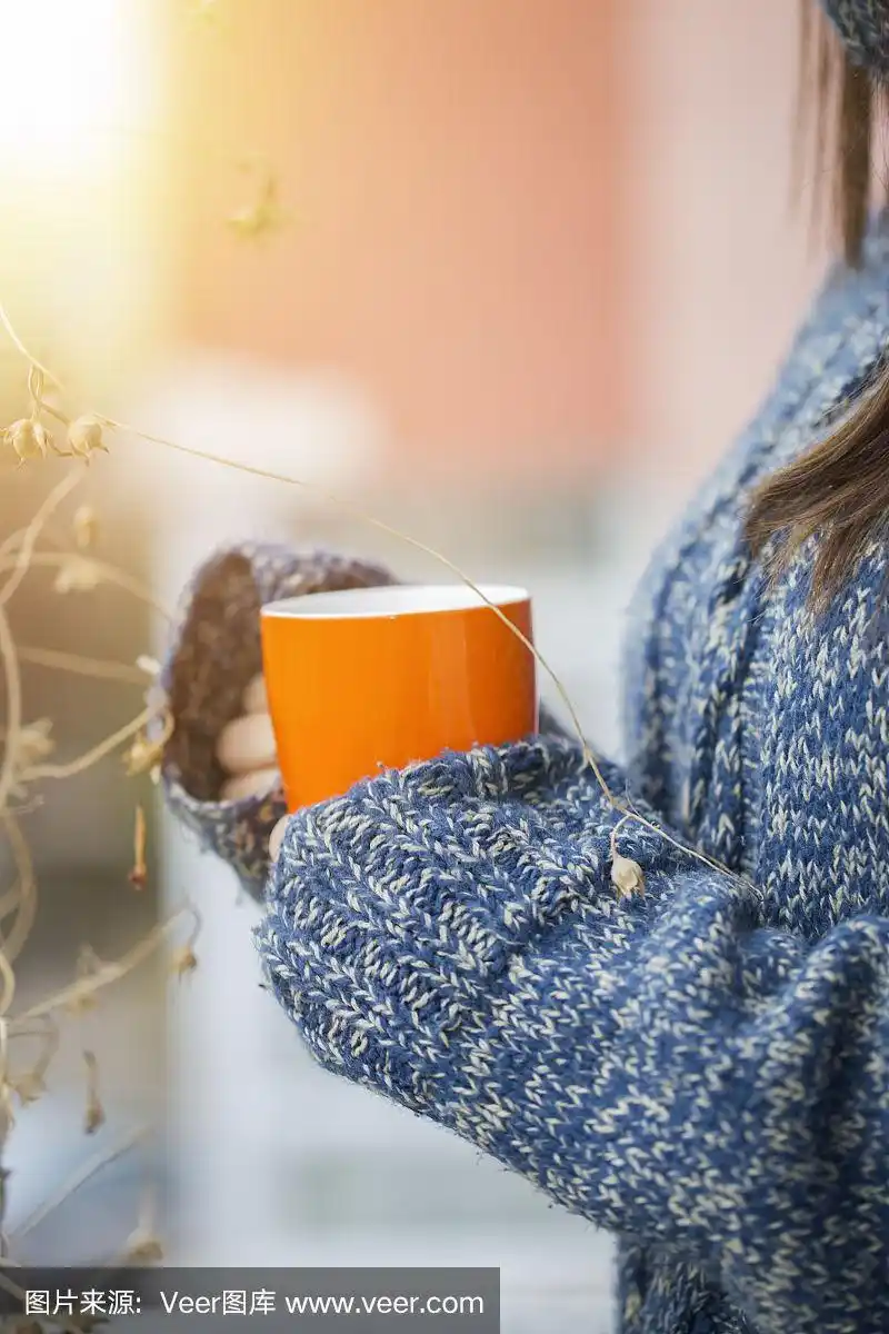 冬日的户外,女人手里拿着一杯热咖啡