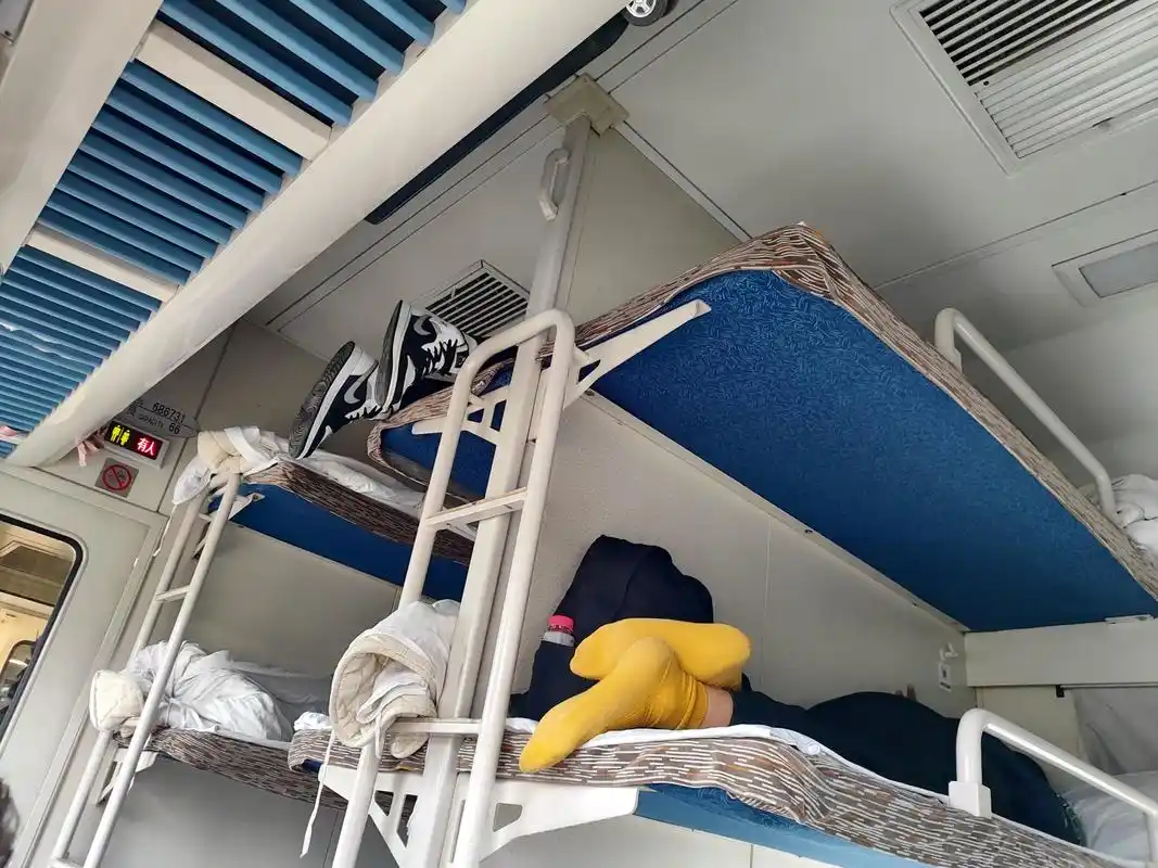 坐火车遇到让人头疼的事情 我的卧铺是中铺,上铺的小伙子穿着鞋子爬到