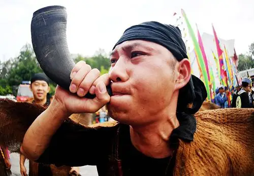 百色市布洛陀民俗文化旅游节举行4月22日,一名壮族青年在吹牛角号,为