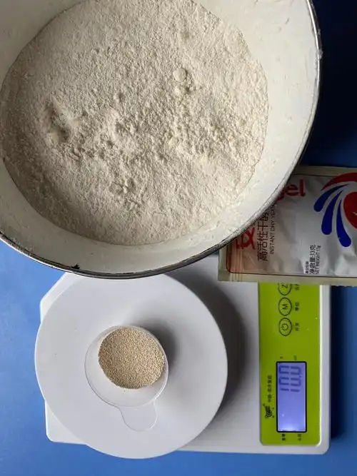 首先准备一千克面粉,十克酵母粉,放了半勺糖,是为了促进酵母更好的