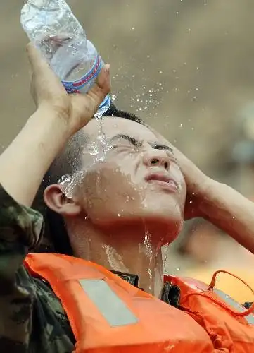 8月4日,一位武警战士往头上浇水降温.新华社记者 李健 摄