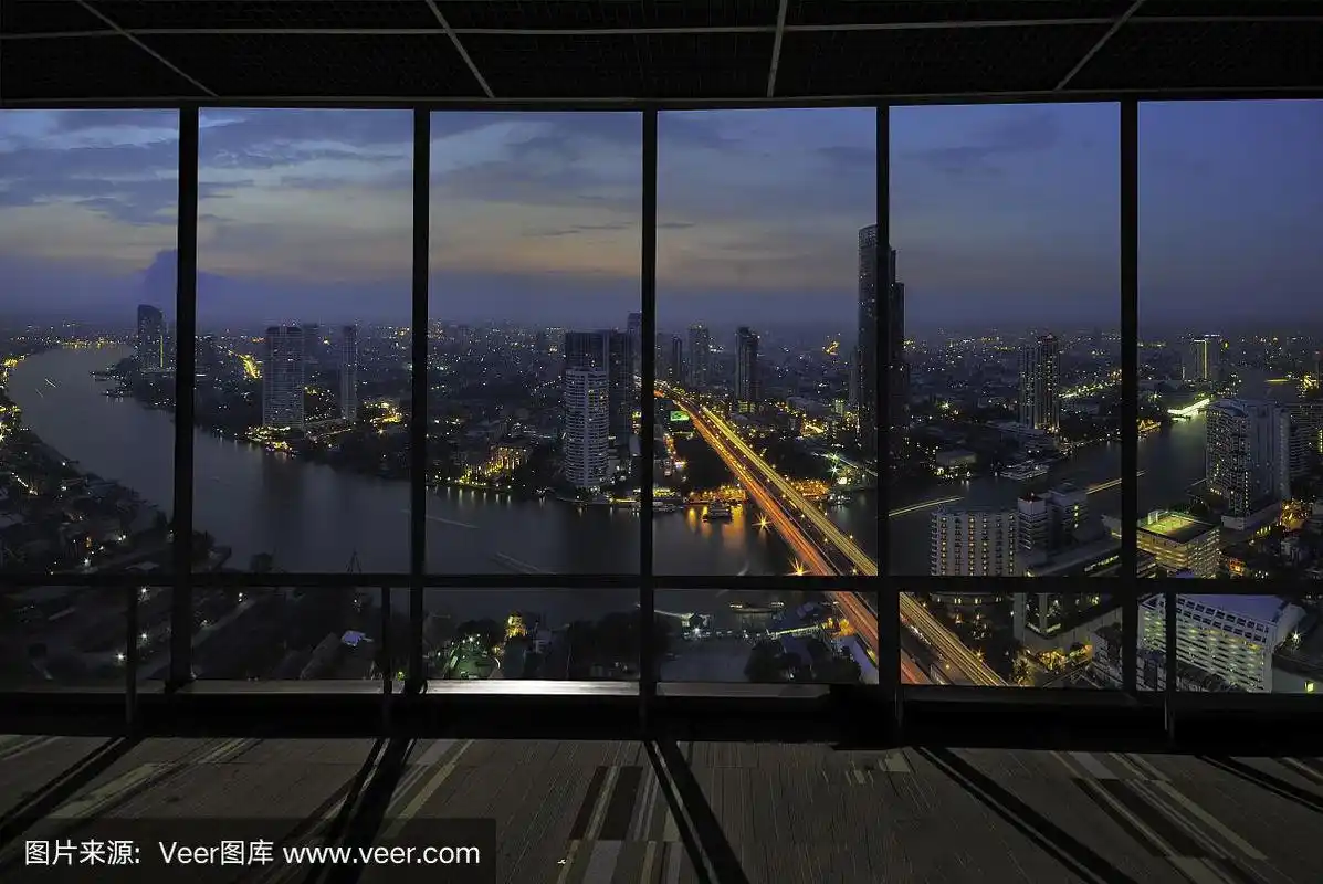 透过现代化办公室的窗户欣赏夜晚的城市.