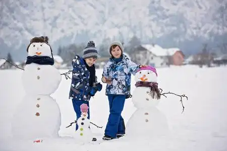 一家人带着孩子,在小村庄的公园里堆雪人照片