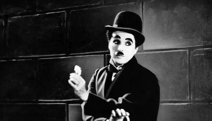 身着燕尾服和肥大的裤子,脚穿一双大头皮鞋,留着一撮小胡子