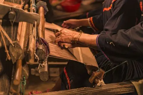 老奶奶正在传授给孙女的传统织布技术.