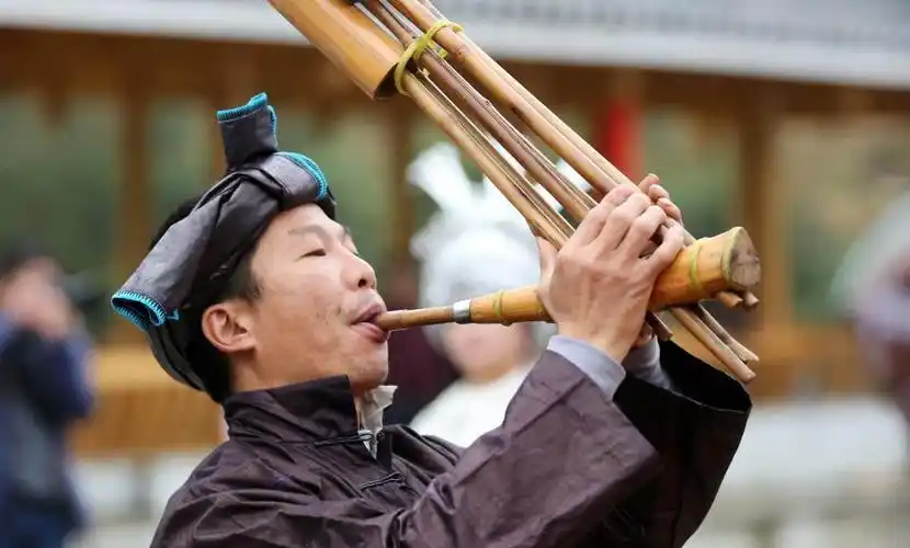 3月23日,一名苗族群众在广西柳州市融安县长安镇安宁村大袍屯吹奏芦笙