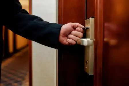 车门锁匠用金属拾取工具关闭锁门用左手金属钥匙抵住树皮木纹钥匙用