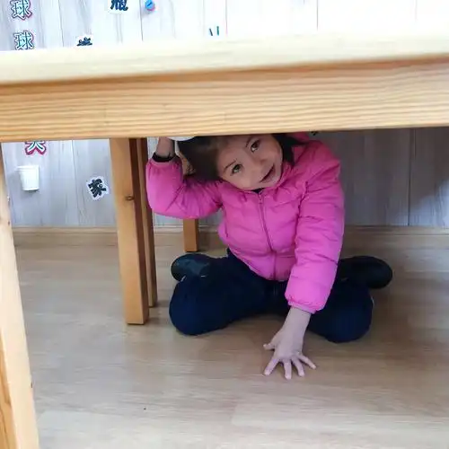 瑾妍小朋友躲在桌子下面