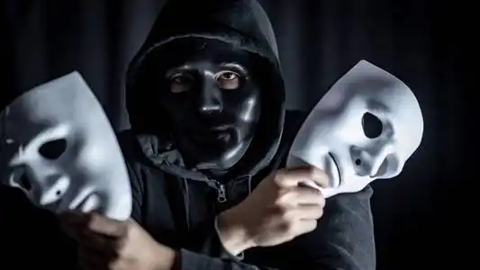 蒙面人神秘的蒙面人戴着黑色面具,手里拿着两个白色面具.