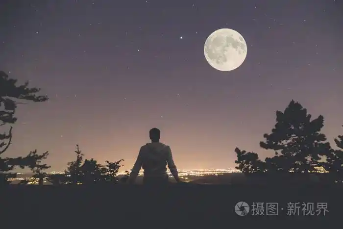 人享受着从城市上空山的景色全月亮和星星