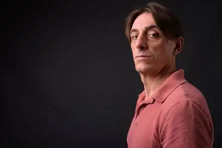 成熟英俊的意大利男人在灰色背景照片