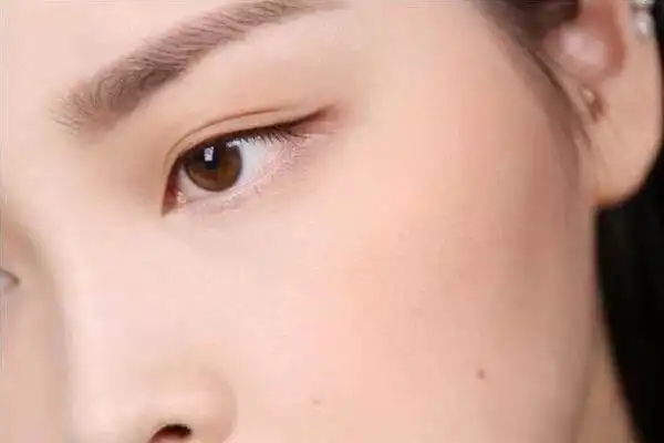 在眼窝刷上咖色眼影,并画一条细细的上眼线,眼尾自然拉长,并微微上扬