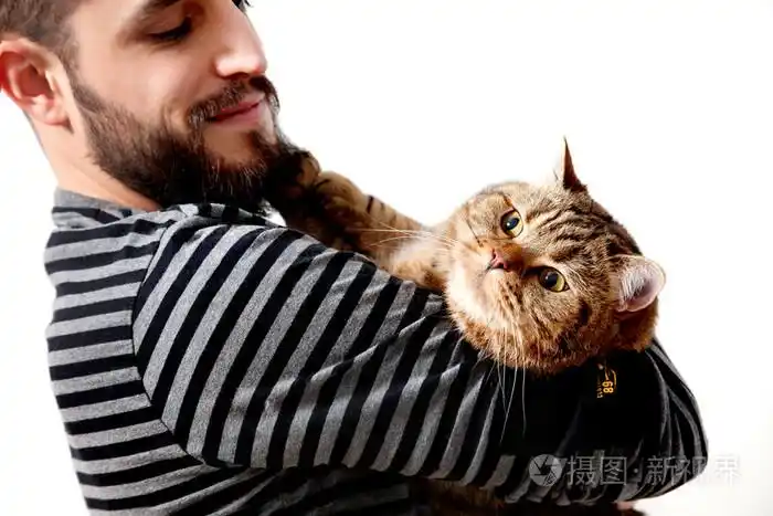 男人抱着他美丽的猫,白色的背景