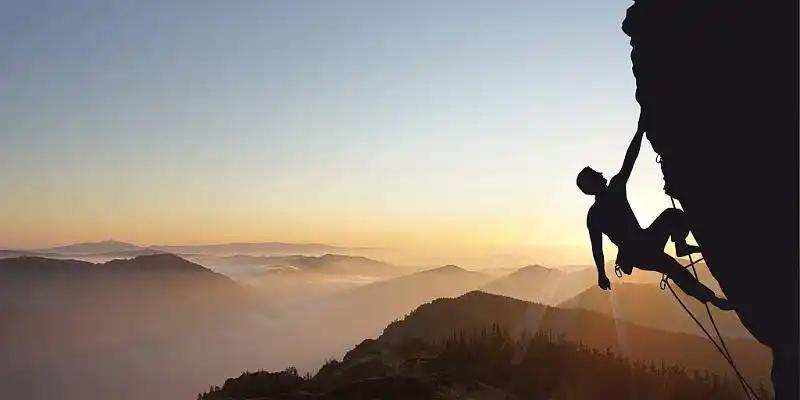 白色光晕人物剪影活动展板背景攀登山顶的人物剪影