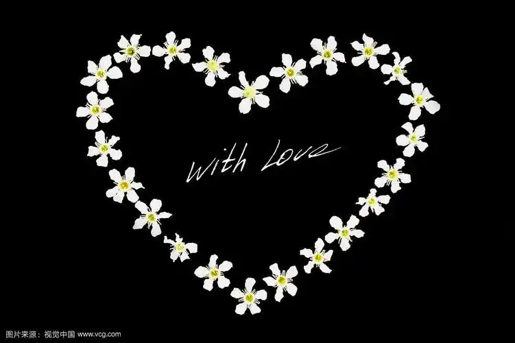 爱心由白花制成,黑色背景上,中间刻有"爱"字样的手写字.
