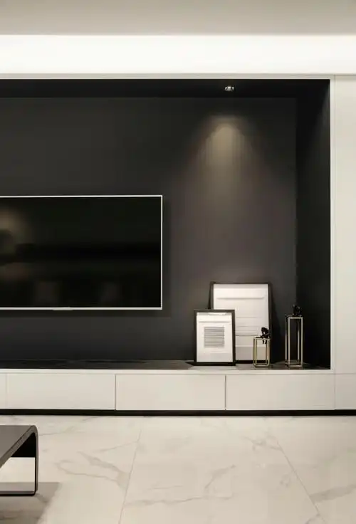 客厅的电视背景墙刷黑色乳胶漆,现场木工制作的电视抽屉柜加定制白色
