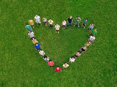 一群人站在心形的草地上图片素材