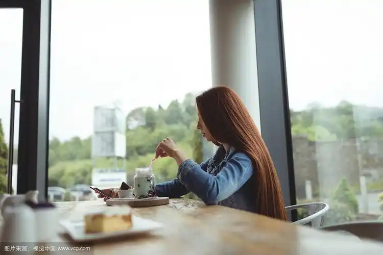 侧面的女人喝,而坐在咖啡馆