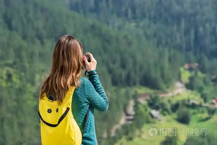 妇女游客与背包和相机拍照户外在夏天的一天