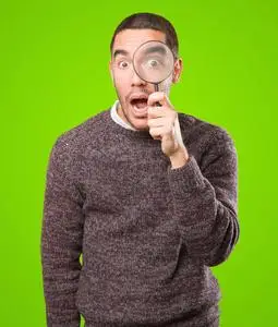 担心的年轻人惊讶惊讶的年轻人使用放大镜照片