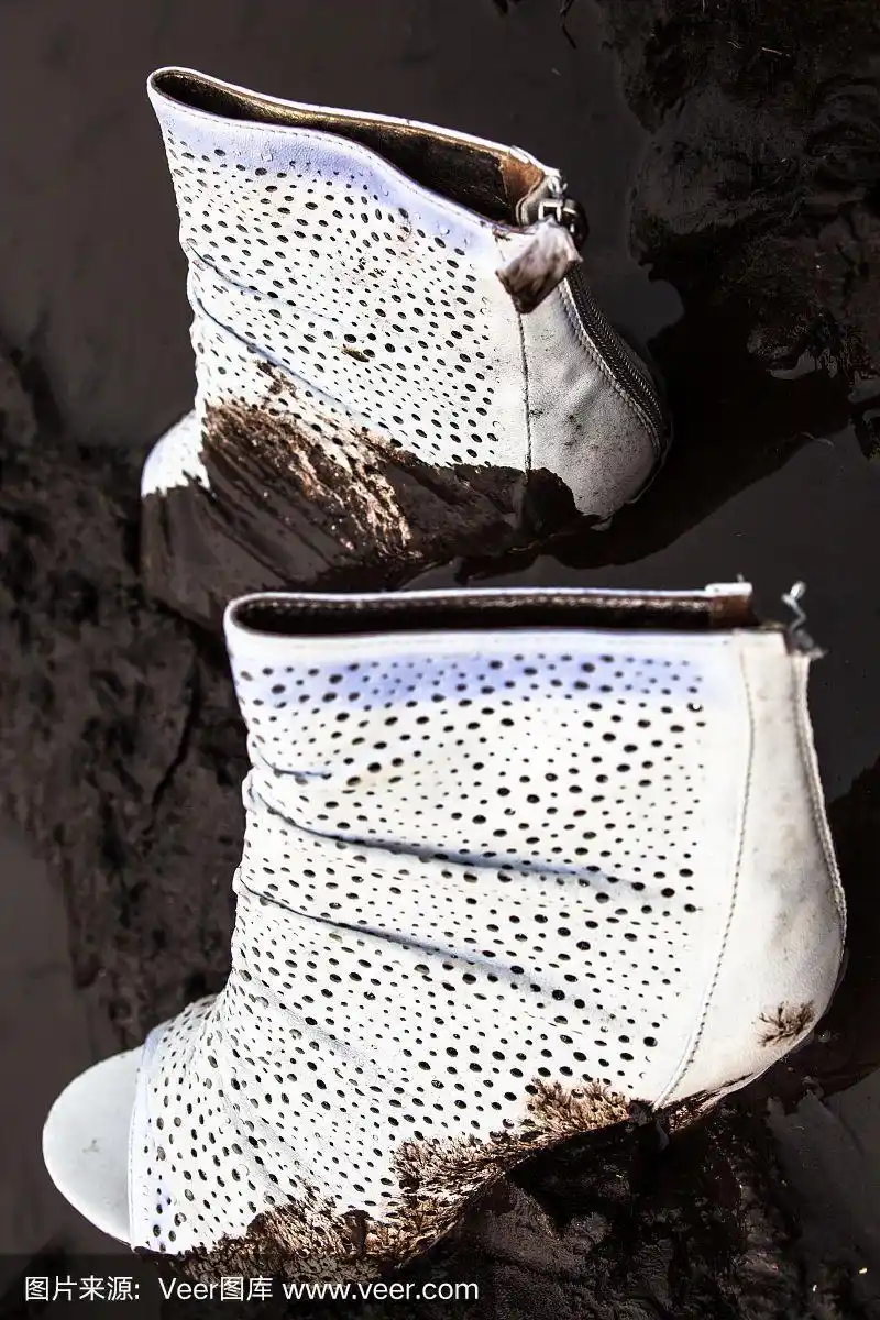 肮脏的白色高跟鞋在泥里