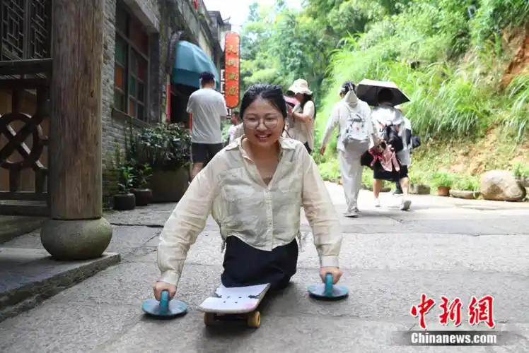 图为2023年暑假,蒋张子怡尝试用滑板代步行走在江西婺源篁岭古朴的
