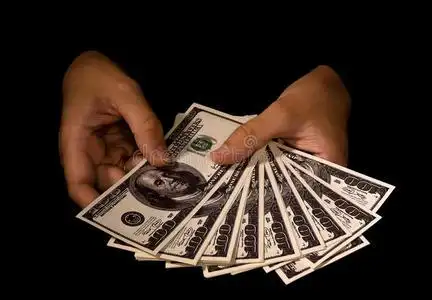 女人的手拿着一包钱照片