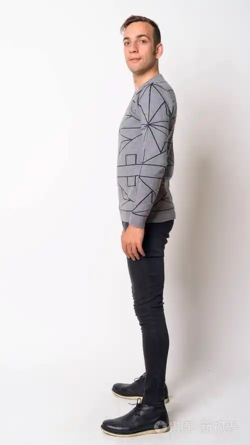 年轻波斯男子仰望相机的全身照片侧视图