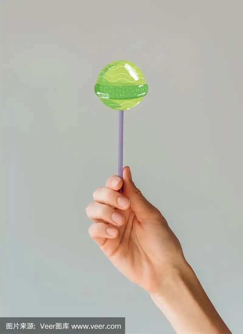 裁剪图像的女人拿着棉花糖在她的手孤立在灰色